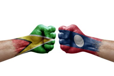 Two hands punch to each others on white background. Country flags painted fists, conflict crisis concept between guyana and laos
