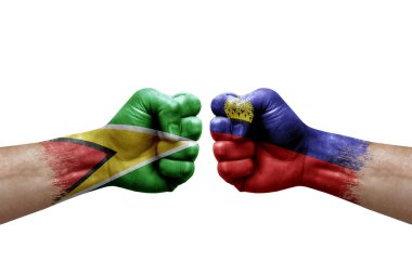 Two hands punch to each others on white background. Country flags painted fists, conflict crisis concept between guyana and liechtenstein