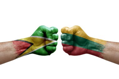 Two hands punch to each others on white background. Country flags painted fists, conflict crisis concept between guyana and lithuania