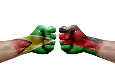 Two hands punch to each others on white background. Country flags painted fists, conflict crisis concept between guyana and malawi