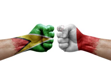 Two hands punch to each others on white background. Country flags painted fists, conflict crisis concept between guyana and malta