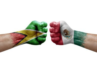 Two hands punch to each others on white background. Country flags painted fists, conflict crisis concept between guyana and mexico