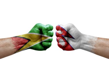 Two hands punch to each others on white background. Country flags painted fists, conflict crisis concept between guyana and nepal