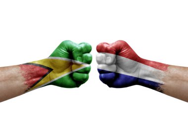 Two hands punch to each others on white background. Country flags painted fists, conflict crisis concept between guyana and netherlands