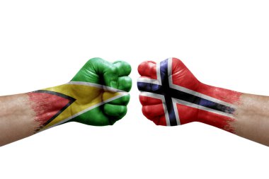 Two hands punch to each others on white background. Country flags painted fists, conflict crisis concept between guyana and norway
