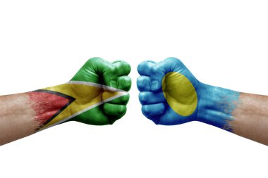 Two hands punch to each others on white background. Country flags painted fists, conflict crisis concept between guyana and palau