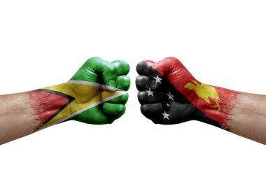 Two hands punch to each others on white background. Country flags painted fists, conflict crisis concept between guyana and papua new guinea