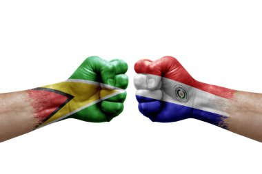Two hands punch to each others on white background. Country flags painted fists, conflict crisis concept between guyana and paraguay
