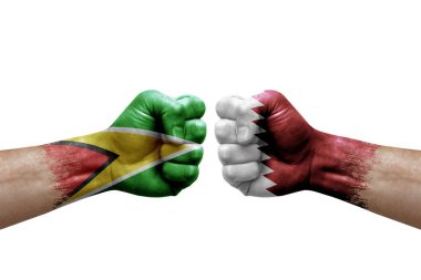 Two hands punch to each others on white background. Country flags painted fists, conflict crisis concept between guyana and qatar