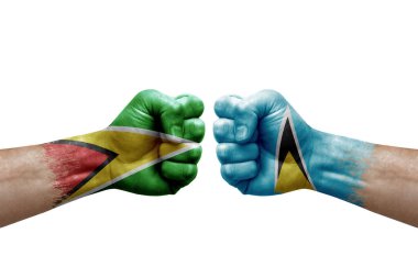 Two hands punch to each others on white background. Country flags painted fists, conflict crisis concept between guyana and saint lucia