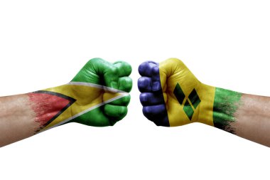 Two hands punch to each others on white background. Country flags painted fists, conflict crisis concept between guyana and saint vincent and the grenadines
