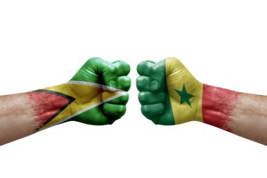 Two hands punch to each others on white background. Country flags painted fists, conflict crisis concept between guyana and senegal