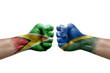 Two hands punch to each others on white background. Country flags painted fists, conflict crisis concept between guyana and solomon islands