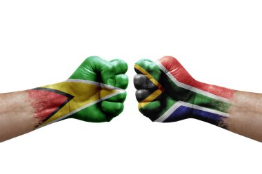 Two hands punch to each others on white background. Country flags painted fists, conflict crisis concept between guyana and south africa