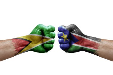 Two hands punch to each others on white background. Country flags painted fists, conflict crisis concept between guyana and south sudan