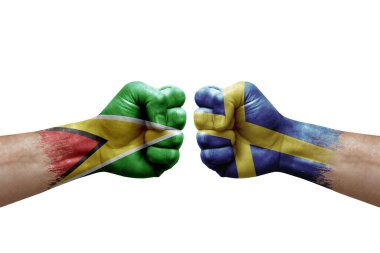 Two hands punch to each others on white background. Country flags painted fists, conflict crisis concept between guyana and sweden