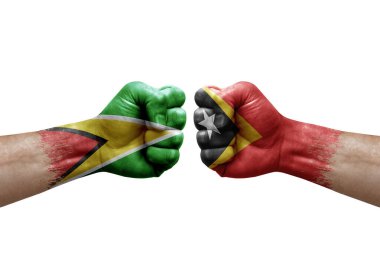 Two hands punch to each others on white background. Country flags painted fists, conflict crisis concept between guyana and timor leste