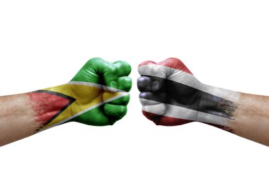 Two hands punch to each others on white background. Country flags painted fists, conflict crisis concept between guyana and thailand