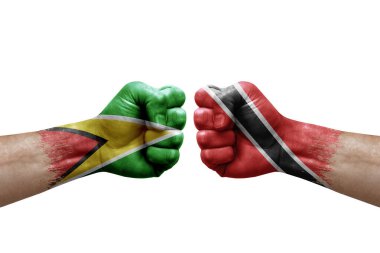 Two hands punch to each others on white background. Country flags painted fists, conflict crisis concept between guyana and tobago