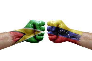 Two hands punch to each others on white background. Country flags painted fists, conflict crisis concept between guyana and venezuela