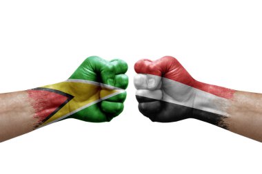 Two hands punch to each others on white background. Country flags painted fists, conflict crisis concept between guyana and yemen