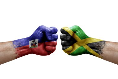 Two hands punch to each others on white background. Country flags painted fists, conflict crisis concept between haiti and jamaica