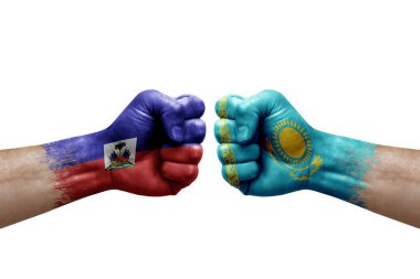 Two hands punch to each others on white background. Country flags painted fists, conflict crisis concept between haiti and kazakhstan