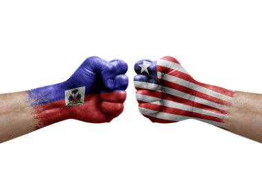 Two hands punch to each others on white background. Country flags painted fists, conflict crisis concept between haiti and liberia
