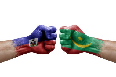 Two hands punch to each others on white background. Country flags painted fists, conflict crisis concept between haiti and mauritania