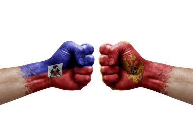 Two hands punch to each others on white background. Country flags painted fists, conflict crisis concept between haiti and montenegro