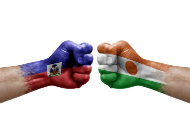 Two hands punch to each others on white background. Country flags painted fists, conflict crisis concept between haiti and niger