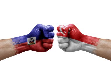 Two hands punch to each others on white background. Country flags painted fists, conflict crisis concept between haiti and singapore
