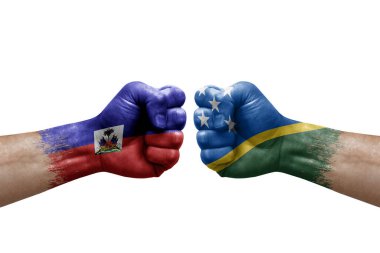 Two hands punch to each others on white background. Country flags painted fists, conflict crisis concept between haiti and solomon islands