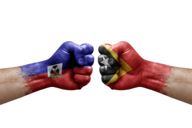 Two hands punch to each others on white background. Country flags painted fists, conflict crisis concept between haiti and timor leste
