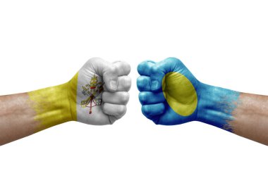 Two hands punch to each others on white background. Country flags painted fists, conflict crisis concept between holy see and palau