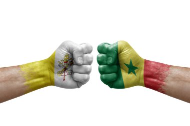Two hands punch to each others on white background. Country flags painted fists, conflict crisis concept between holy see and senegal