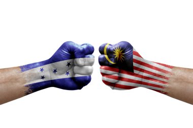 Two hands punch to each others on white background. Country flags painted fists, conflict crisis concept between honduras and malaysia