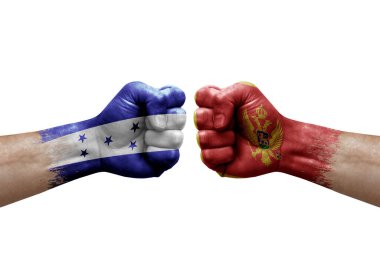 Two hands punch to each others on white background. Country flags painted fists, conflict crisis concept between honduras and montenegro