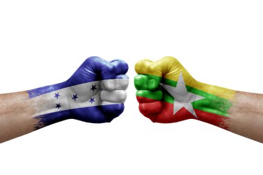 Two hands punch to each others on white background. Country flags painted fists, conflict crisis concept between honduras and myanmar