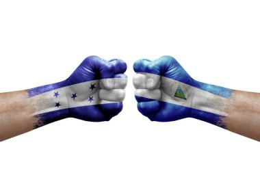 Two hands punch to each others on white background. Country flags painted fists, conflict crisis concept between honduras and nicaragua