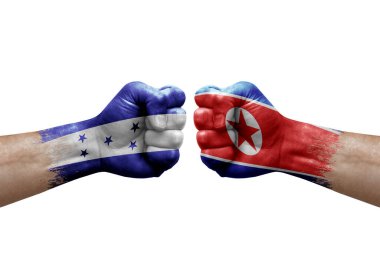 Two hands punch to each others on white background. Country flags painted fists, conflict crisis concept between honduras and north korea