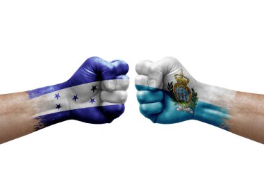 Two hands punch to each others on white background. Country flags painted fists, conflict crisis concept between honduras and san marino