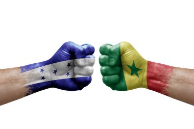 Two hands punch to each others on white background. Country flags painted fists, conflict crisis concept between honduras and senegal