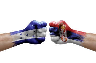 Two hands punch to each others on white background. Country flags painted fists, conflict crisis concept between honduras and serbia