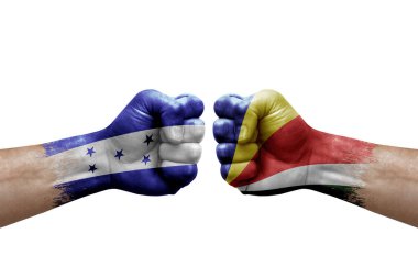 Two hands punch to each others on white background. Country flags painted fists, conflict crisis concept between honduras and seychelles