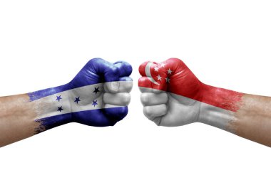 Two hands punch to each others on white background. Country flags painted fists, conflict crisis concept between honduras and singapore