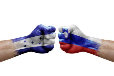 Two hands punch to each others on white background. Country flags painted fists, conflict crisis concept between honduras and slovenia