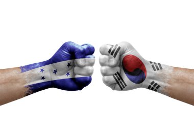 Two hands punch to each others on white background. Country flags painted fists, conflict crisis concept between honduras and south korea