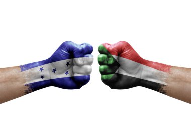 Two hands punch to each others on white background. Country flags painted fists, conflict crisis concept between honduras and sudan