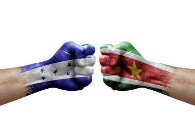 Two hands punch to each others on white background. Country flags painted fists, conflict crisis concept between honduras and suriname